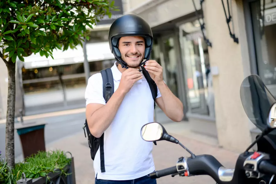 Eine Person, die sich mit Lernmaterialien und einem Motorradhelm auf die A1 Führerschein Prüfung vorbereitet