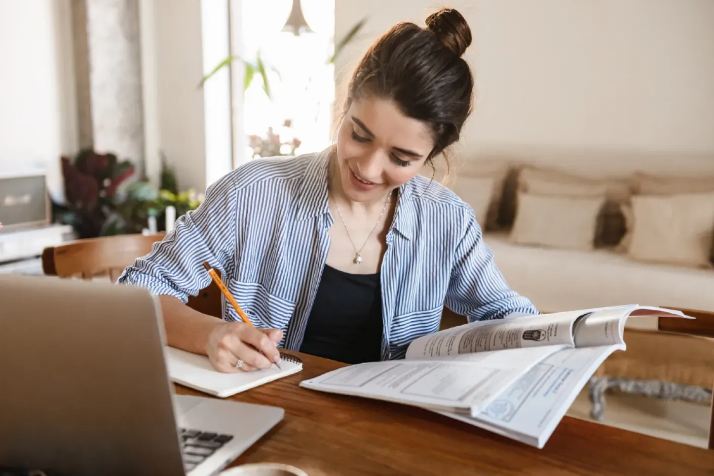 A student studying ukiset essay questions with various resources